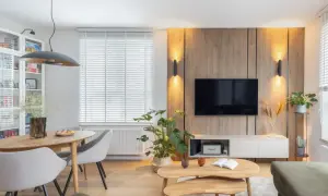 Przytulny salon inspiracje: drewniana ściana z TV, jadalnia, rośliny i wygodna sofa tworzą ciepłą atmosferę.