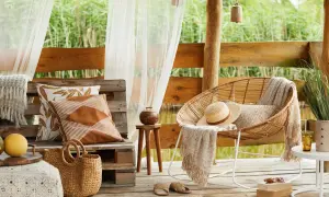 Relaks na tarasie w stylu boho. Inspiracje z wiklinowym fotelem, plecionym koszem i lnianymi poduszkami.