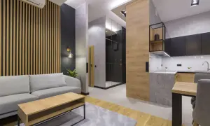 Nowoczesny salon z sofą i stolikiem kawowym. Ściana za sofą ozdobiona jest pionowymi lamelami, które nadają wnętrzu ciepła i elegancji.