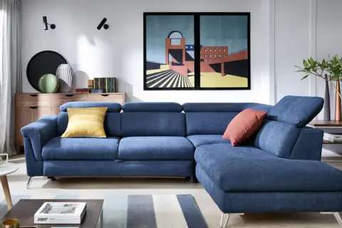 Niebieska, narożna sofa z poduszkami to idealny wypoczynek do salonu. Nowoczesny design i komfort zachwycą każdego.